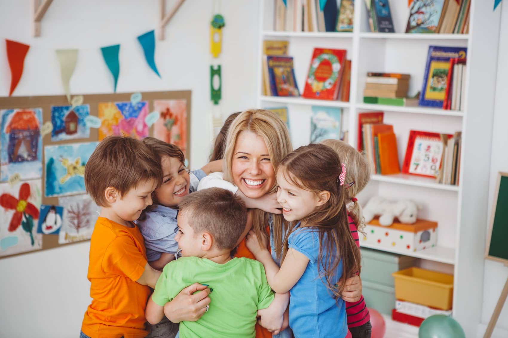 Kids in kindergarden playing with their teacher