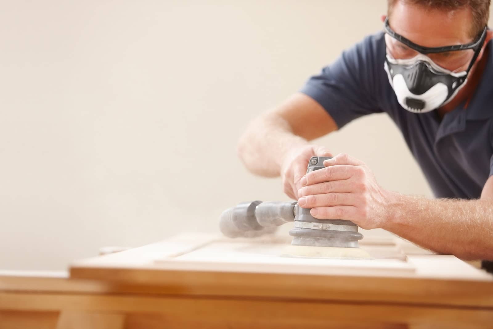 Carpenter using an electric sander