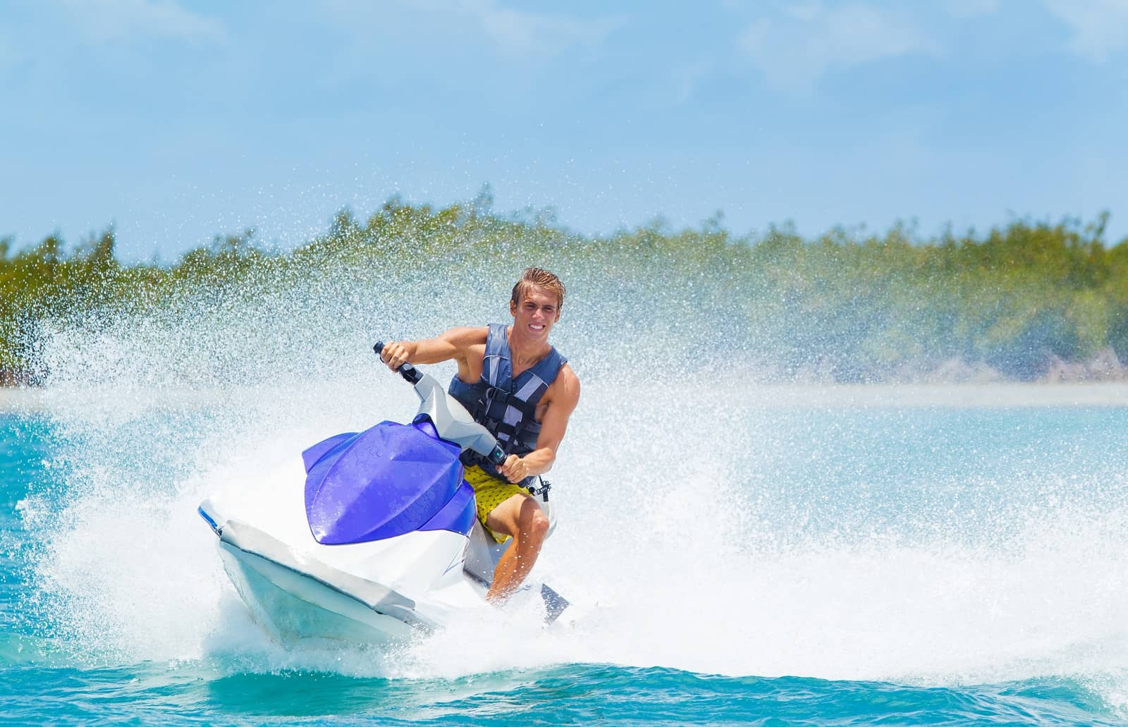 Man turning jet ski on bright blue water