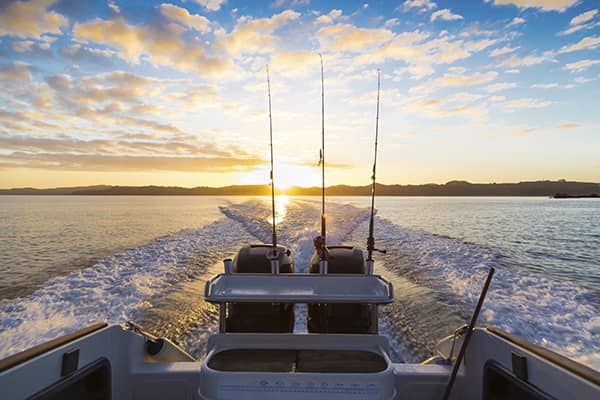 Boat cresting into the sunset