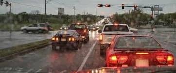 Car brake lights at a traffic light in the rain